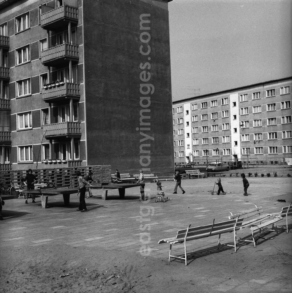Fürstenwalde: Kinder spielen Tischtennis. Im Bild: ein Spielplatz mit Tischtennisplatten im Neubaugebiet. Einige Neubauten sind teilweise mit Fahnen / Flaggen geschmückt. Im Hintergrund: Fahrräder, ein PKW Typ Trabant und ein PKW Typ Citroën DS.