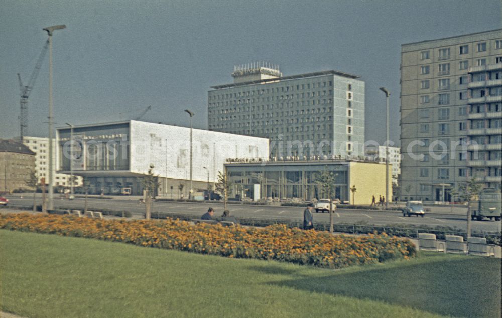 GDR photo archive: Berlin - Pedestrians and passers-by in traffic stroll along the boulevard of Stalinallee - Karl-Marx-Allee at the INTERNATIONAL cinema and the Hotel Berolina in the Mitte district of Berlin East Berlin on the territory of the former GDR, German Democratic Republic