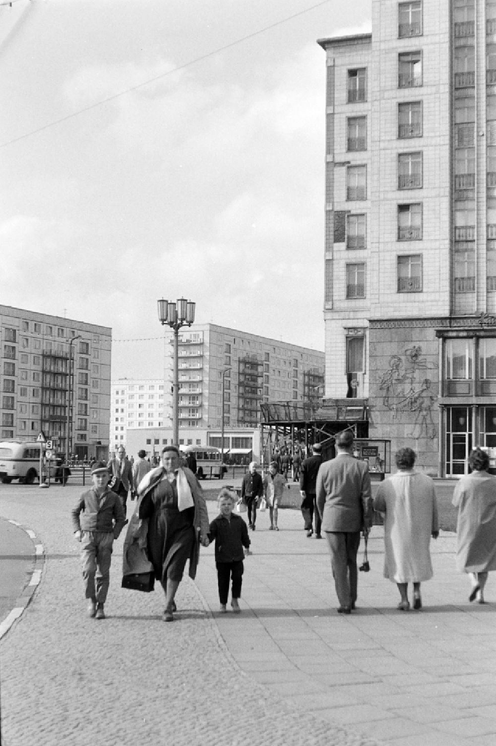 GDR photo archive: Berlin - Pedestrians and passers-by in traffic with children on place Strausberger Platz in the district Friedrichshain in Berlin Eastberlin on the territory of the former GDR, German Democratic Republic