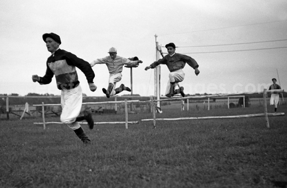 Dresden: Jockeys jump over a hurdle without horses at Dresden-Seidnitz racecourse in the state Saxony on the territory of the former GDR, German Democratic Republic