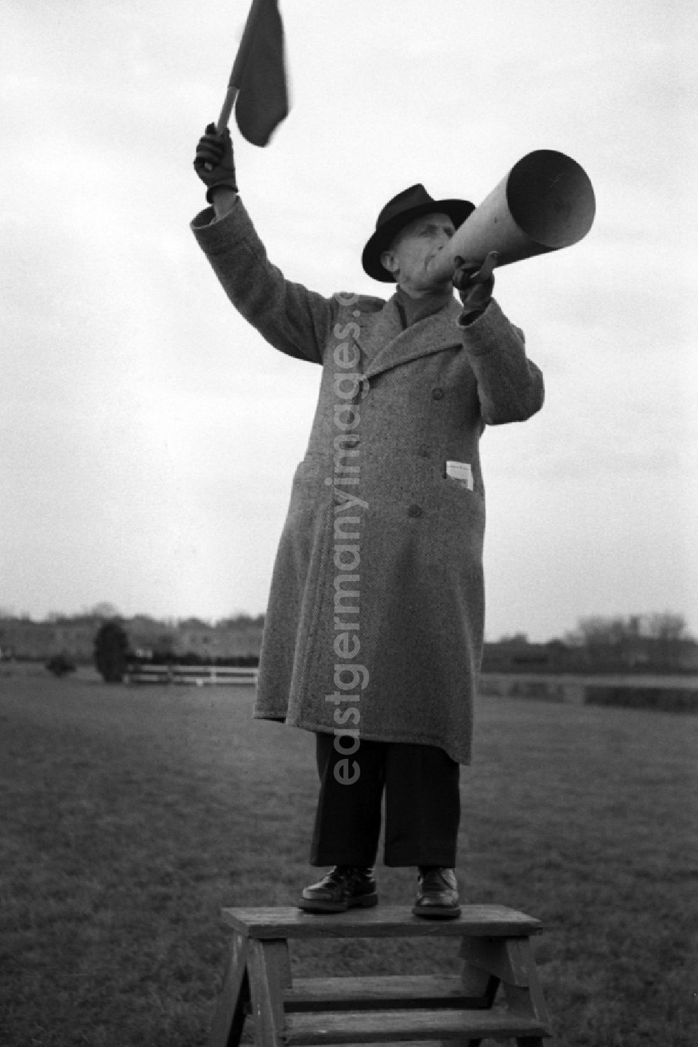 GDR picture archive: Dresden - Man holds up a flag and shouts into a megaphone at the Dresden-Seidnitz racecourse in Dresden in the state Saxony on the territory of the former GDR, German Democratic Republic