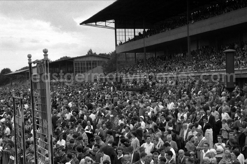 GDR photo archive: Hoppegarten - Spectators in front of and on the main grandstand of the racecourse in Hoppegarten in the state Brandenburg on the territory of the former GDR, German Democratic Republic