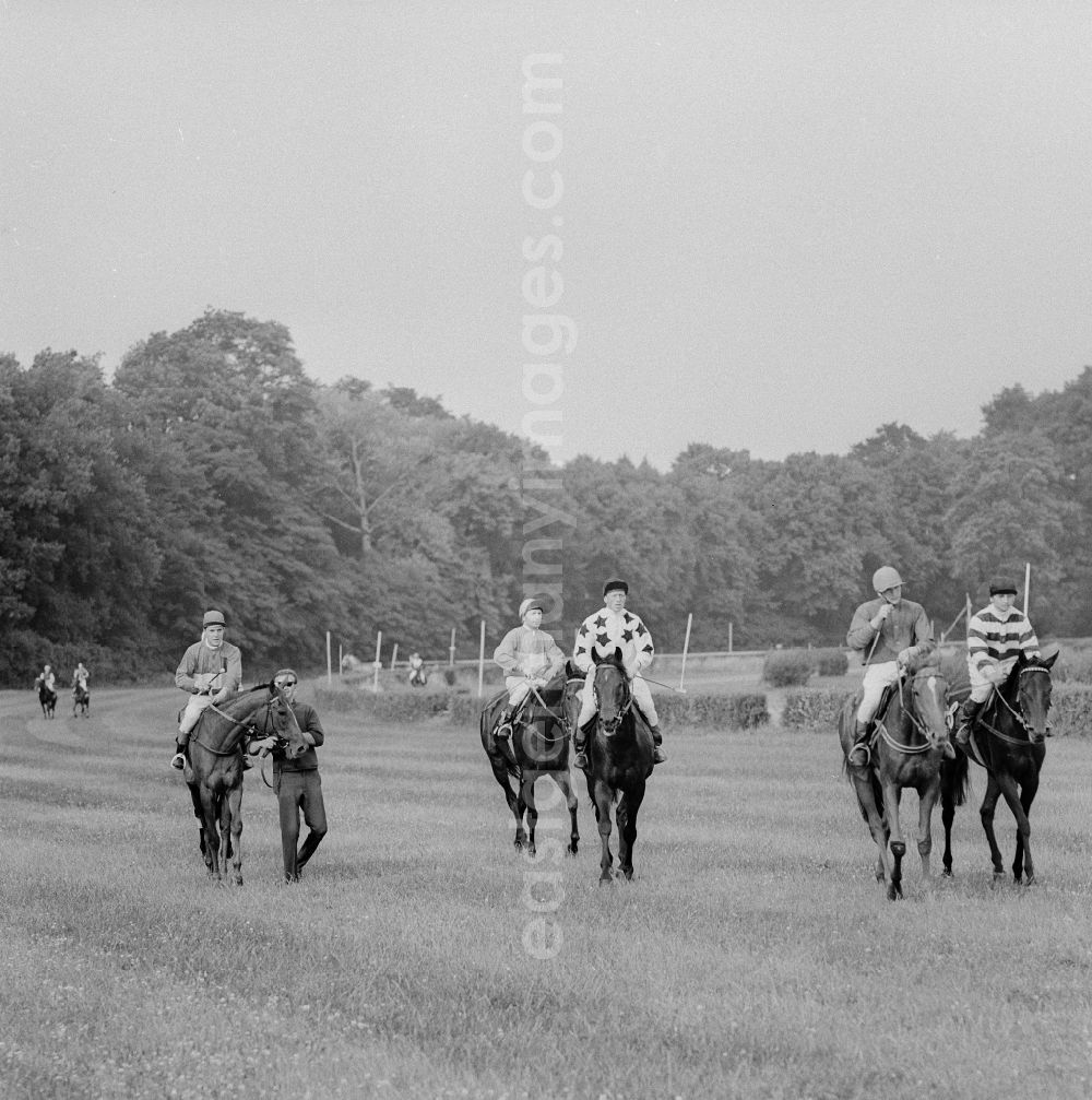 GDR photo archive: Hoppegarten - Racehorses and jockeys at the last training lap, at the Hoppegarten racecourse, before the start of the German Derby of the GDR in Hoppegarten in the federal state Brandenburg on the territory of the former GDR, German Democratic Republic