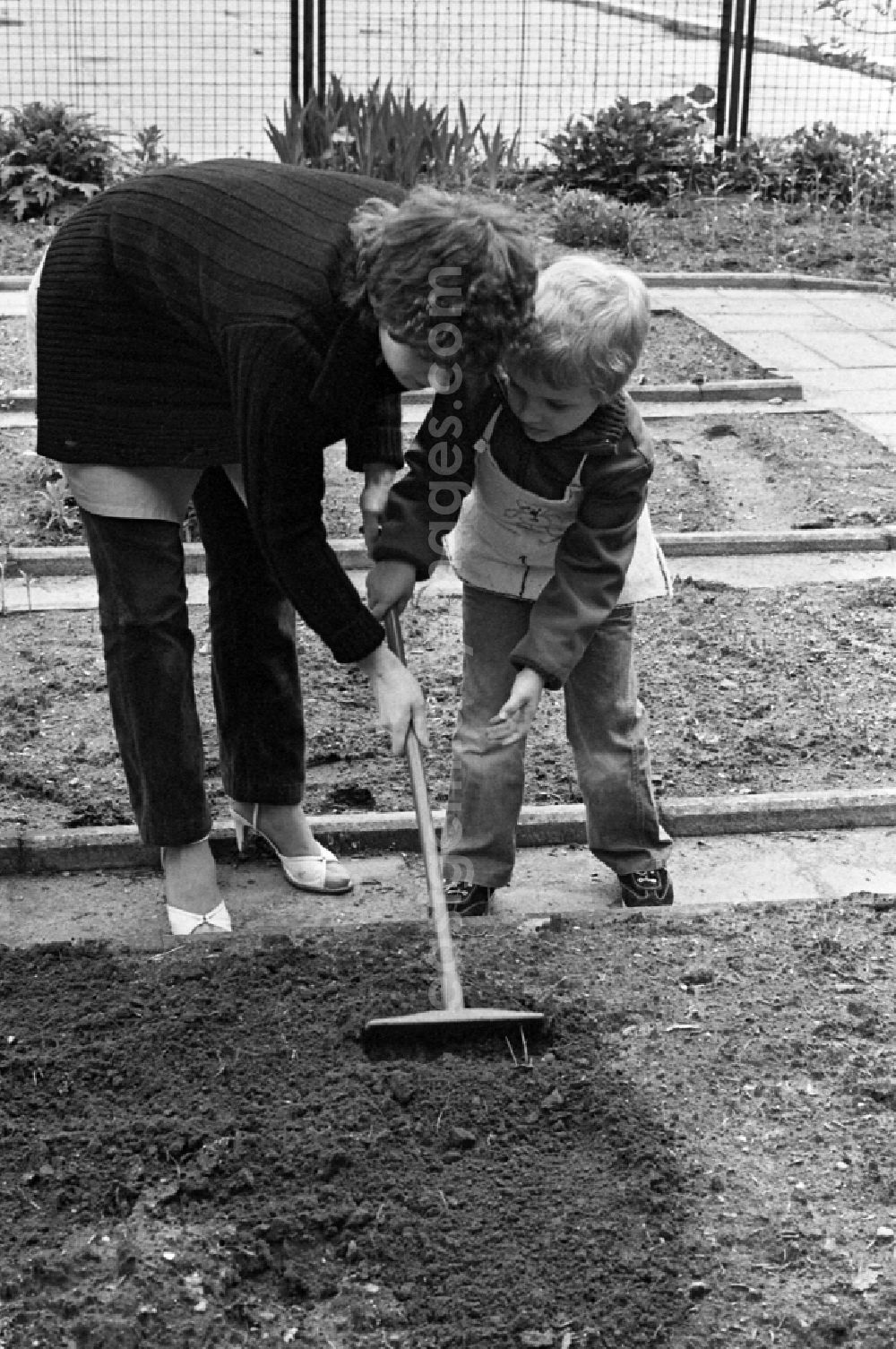 Berlin: Games and fun with toddlers in kindergarten with instructions for gardening in the school garden in Berlin Eastberlin, the former capital of the GDR, German Democratic Republic