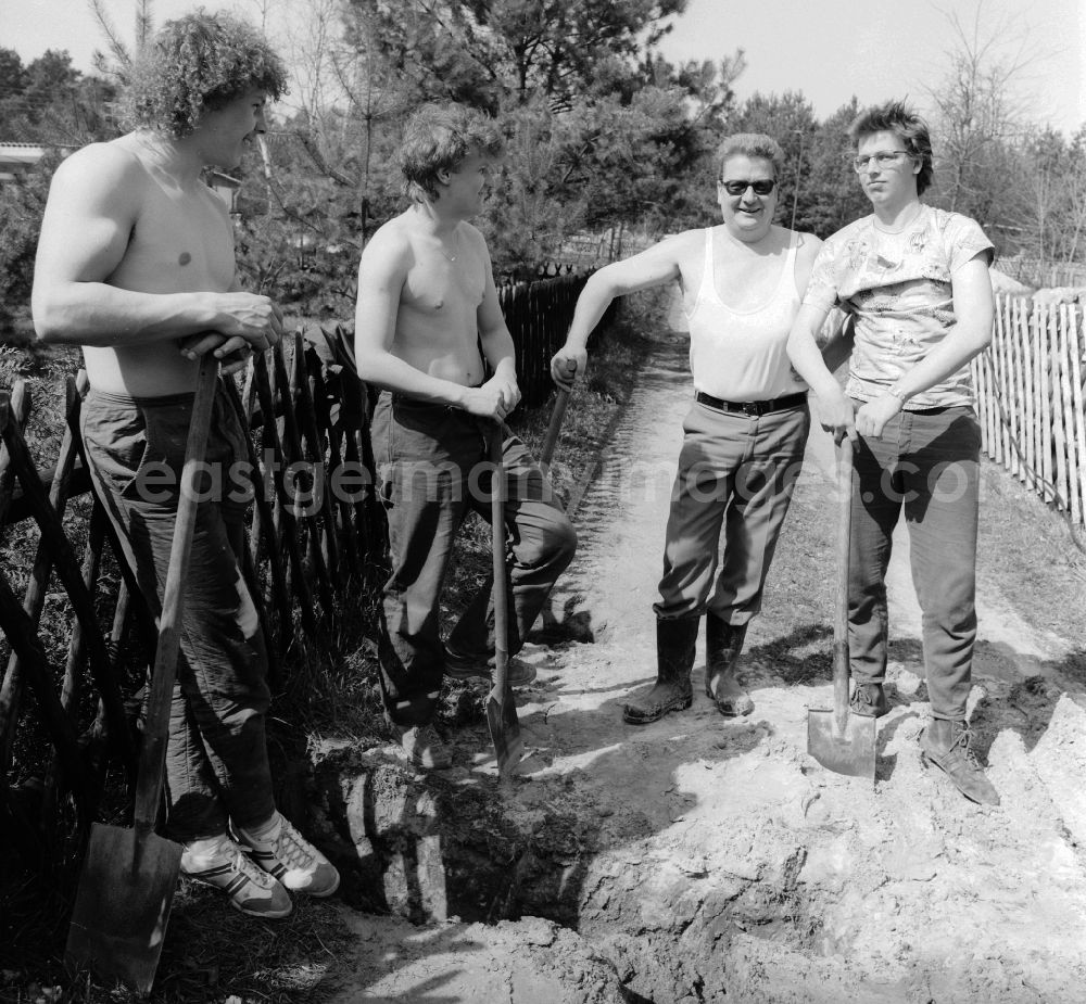 GDR photo archive: Teupitz - Garden owners and residents dig a cable trench together in Teupitz in the federal state of Brandenburg on the territory of the former GDR, German Democratic Republic