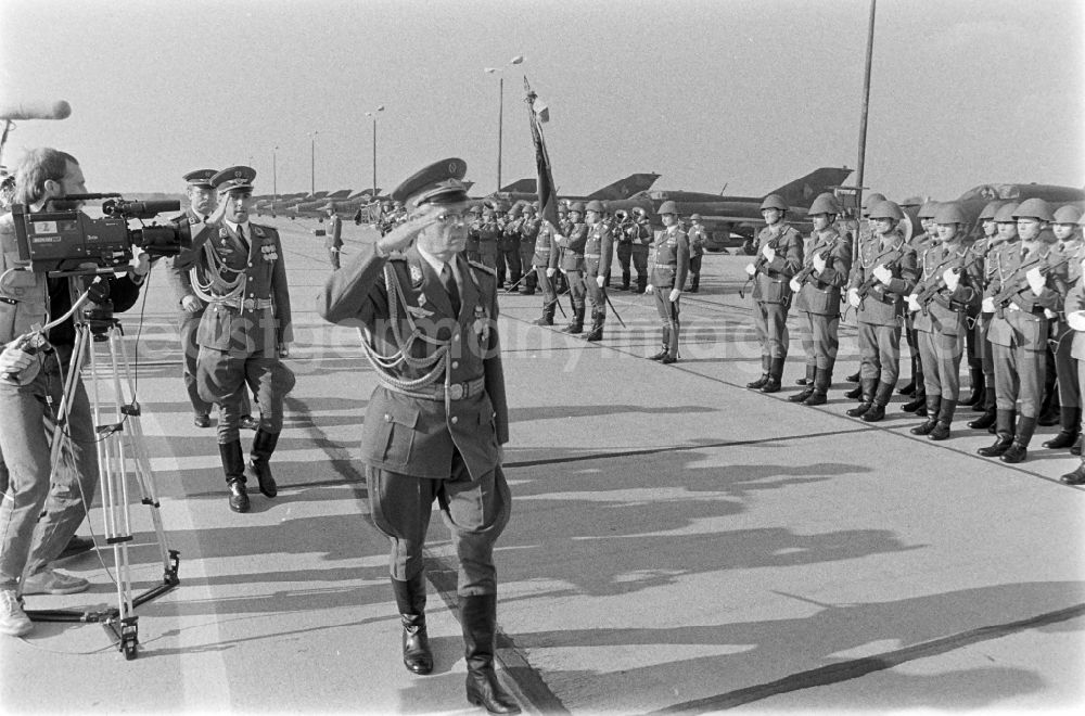GDR image archive: Jänschwalde - Colonel-General Wolfgang Reinhold, head of the LSK/LV air force - air defense walking the honor formation on the occasion of the media-effective presentation of flight technology and equipment of the MiG-21 PFM weapon system as part of a disarmament campaign at the Drewitz airfield of the Wilhelm Pieck fighter squadron of the National People's Army NVA office in Jaenschwalde in the state of Brandenburg on the territory of the former GDR, German Democratic Republic