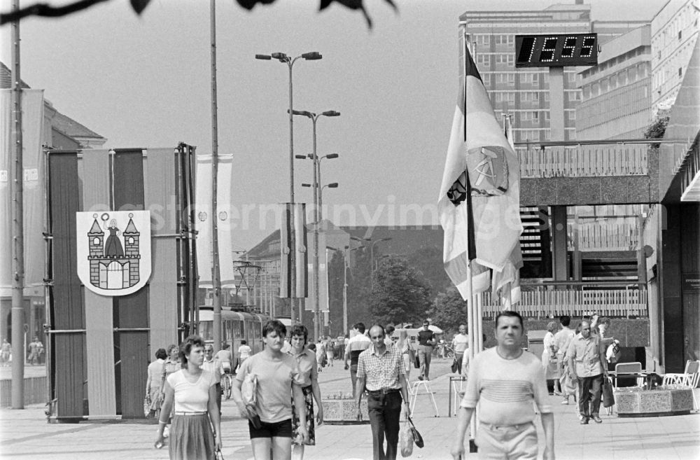 GDR image archive: Magdeburg - People stroll along Karl-Marx-Strasse (today Breiter Weg) in Magdeburg, Saxony-Anhalt in the area of the former GDR, German Democratic Republic. Everything is festively decorated on the occasion of the 21st Workers' Festival