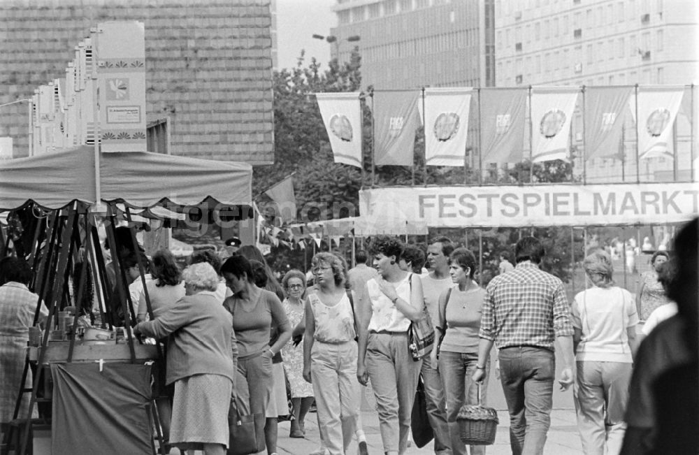 GDR picture archive: Magdeburg - People stroll along Karl-Marx-Strasse (today Breiter Weg) in Magdeburg, Saxony-Anhalt in the area of the former GDR, German Democratic Republic. Everything is festively decorated on the occasion of the 21st Workers' Festival