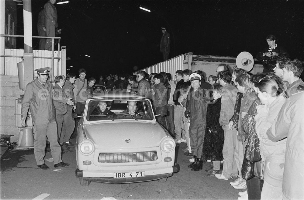 GDR image archive: Berlin - Grenzöffnung am ehemaligen Grenzübergang Invalidenstrasse in Mitte. Auto vom Typ Trabant überquert durch ein Tor die Grenze der DDR nach West-Berlin, drumherum stehen Schaulustige und Polizisten.