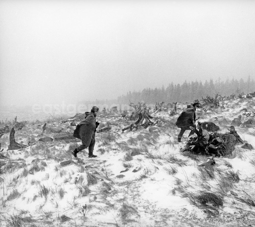 GDR photo archive: Abbenrode - Border Patrol in snow in the winter with dog, car and motorcycle near Abbenrode in today's federal state of Saxony-Anhalt. The border guards are equipped with AK-47 machine guns