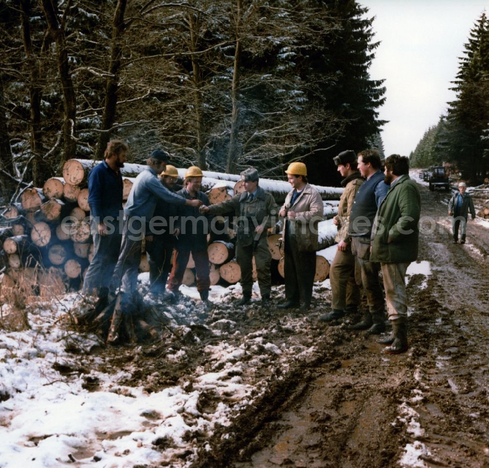 GDR picture archive: Lindewerra - Wahlhausen - Border Patrol in snow in winter on the border strip in conversation with forestry workers in a wooded area near Lindewerra - Wahlshausen in present-day state of Saxony-Anhalt. The border guards of the border troops of the GDR - walls are equipped with AK-47 machine guns