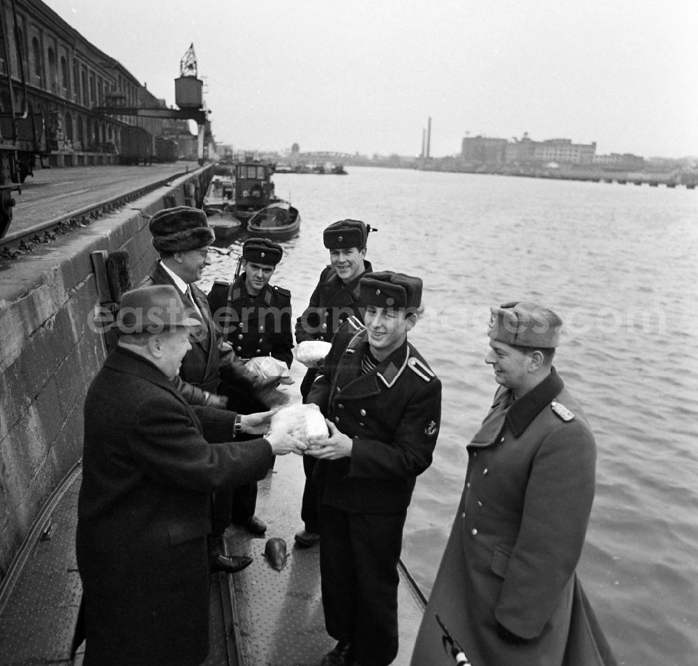 Berlin: Soldiers in the uniform of the border troops - sailors of the boat company of the border regiment - 36 Helmut Poppe at the presentation of New Year's gifts by the 1st Secretary of the SED - district leadership Gerhard Kowalschik on the banks of the Spree of the Berlin Osthafen in the district of Friedrichshain in Berlin East Berlin in the area of former GDR, German Democratic Republic
