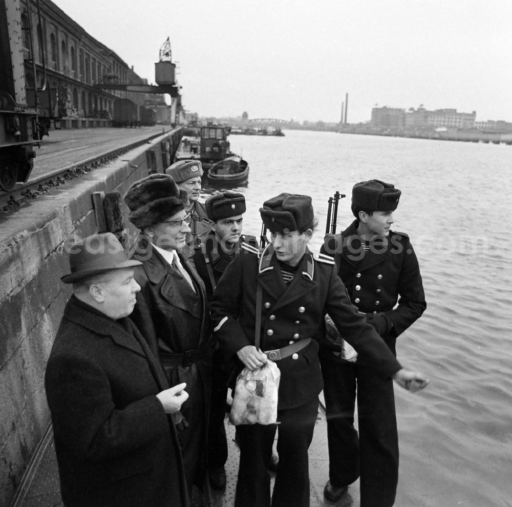 Berlin: Soldiers in the uniform of the border troops - sailors of the boat company of the border regiment - 36 Helmut Poppe at the presentation of New Year's gifts by the 1st Secretary of the SED - district leadership Gerhard Kowalschik on the banks of the Spree of the Berlin Osthafen in the district of Friedrichshain in Berlin East Berlin in the area of former GDR, German Democratic Republic