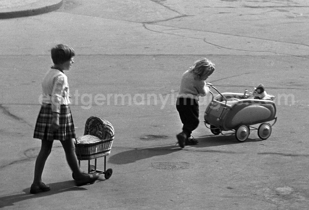 GDR image archive: Leipzig - Laß sie ja nicht rausfallen, scheint das linke um ihre Puppe besorgte Mädchen ihrer kleinen Schwester zuzurufen, mit der sie kurz ihren Puppenwagen getauscht hatte.