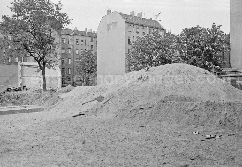 GDR image archive: Berlin - Fun and games for children and teenagers on a heap of sand on a construction site on street Corinthstrasse in Berlin Eastberlin on the territory of the former GDR, German Democratic Republic