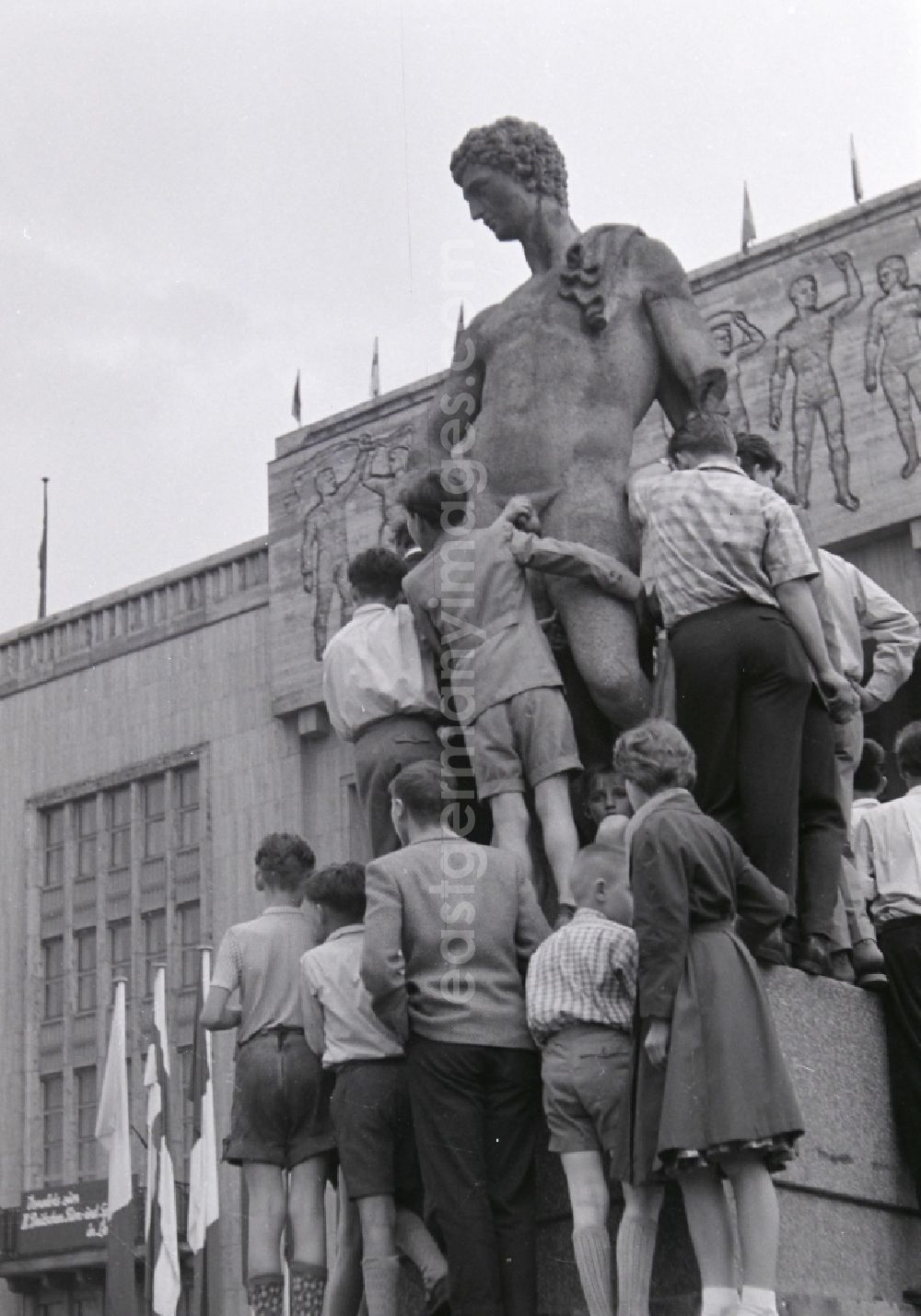 GDR photo archive: Berlin - Fun and games for children and teenagers in front of a stone sculpture in front of the Deutsche Sporthalle on Stalinallee - today's Karl-Marx-Allee in the district Friedrichshain in Berlin, the former capital of the GDR, German Democratic Republic