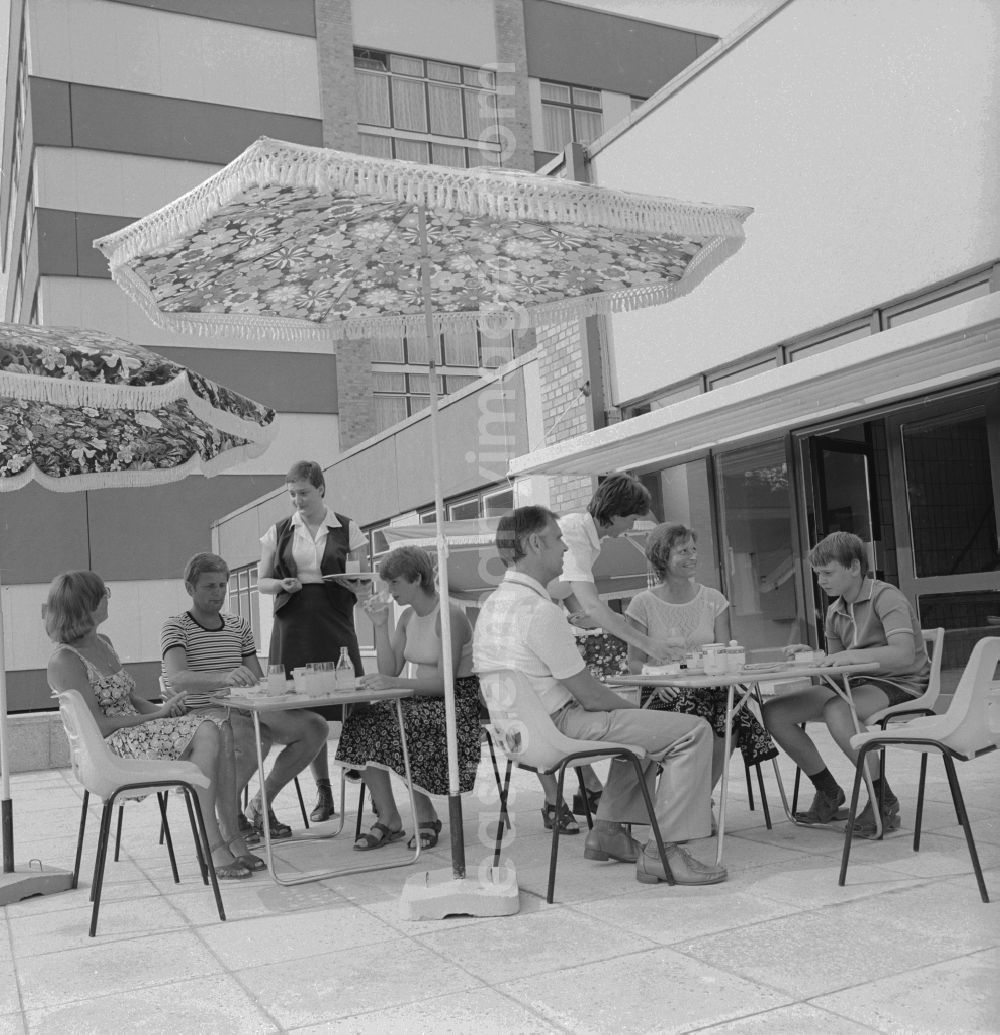 Ückeritz: Guests drink coffee on the outdoor terrace under a parasol Somme in Ueckeritz in Mecklenburg-Western Pomerania in the field of the former GDR, German Democratic Republic