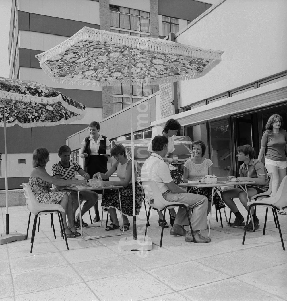 GDR image archive: Ückeritz - Guests drink coffee on the outdoor terrace under a parasol Somme in Ueckeritz in Mecklenburg-Western Pomerania in the field of the former GDR, German Democratic Republic