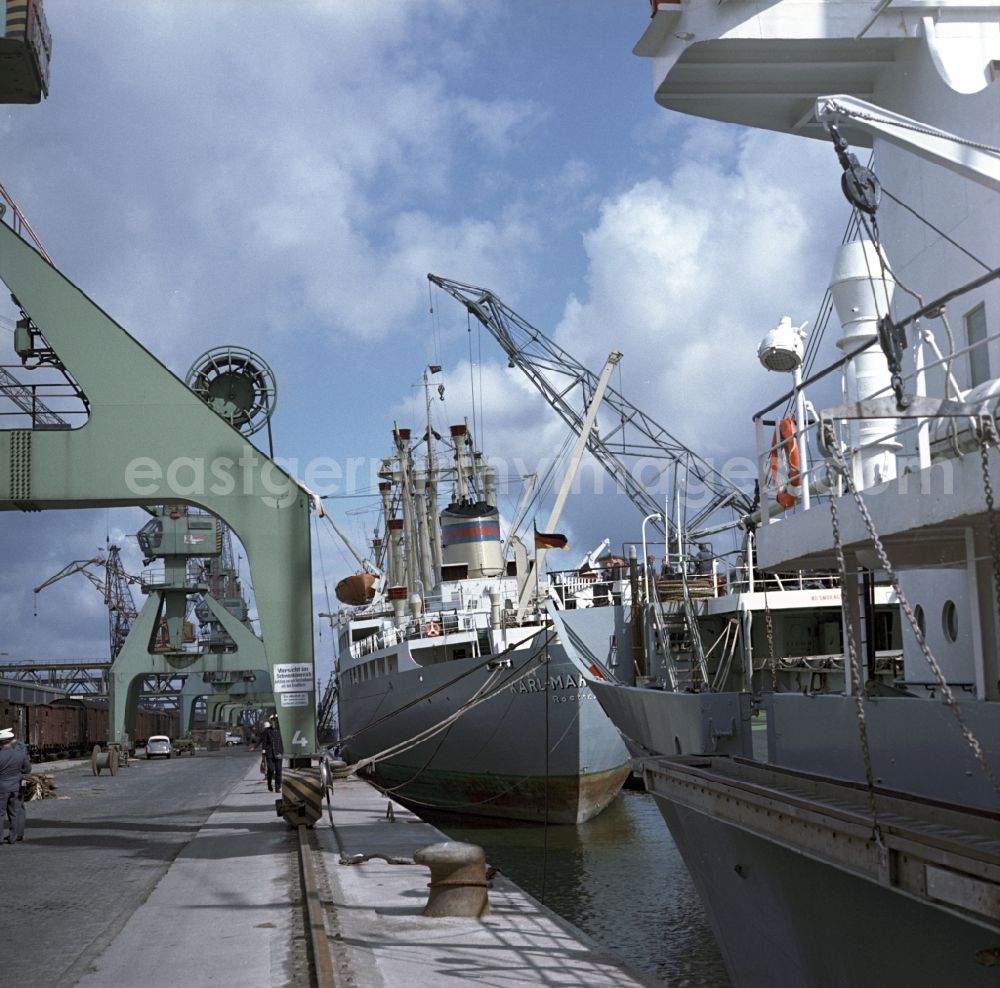 GDR picture archive: Rostock - Merchant ships in the seaport of Rostock in Mecklenburg - Western Pomerania. Here during loading at the port. By the division of Germany resulted in the need to build on the Baltic coast of East Germany a seaport
