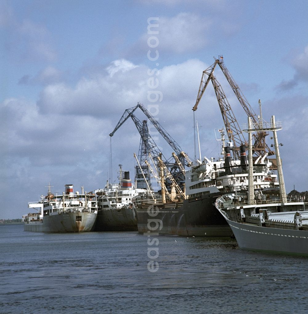GDR image archive: Rostock - Merchant ships in the seaport of Rostock in Mecklenburg - Western Pomerania. Here during loading at the port. By the division of Germany resulted in the need to build on the Baltic coast of East Germany a seaport