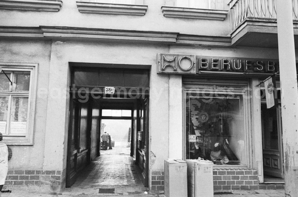 GDR photo archive: Berlin - House front and Shopwindow for workwear retail store in the borough Berlin-Pankow or Prenzlauer Berg