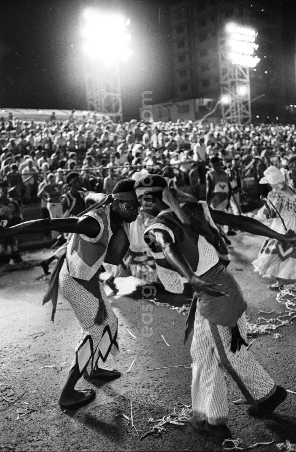 GDR picture archive: Havanna - Karneval während der XI. Weltfestspiele der Jugend und Studenten vom 28.07. - 05.08.1978. Im Fokus zwei Tänzer, die einander umkreisen. Im Hintergrund: vollbesetzte Zuschauertribünen. Karneval hat auf Kuba eine lange Tradition, besonders in Santiago de Cuba. Er verschmilzt karibische, brasilianische und afrikanische Einflüsse. Die Weltfestspiele standen unter dem Motto: Für antiimperialistische Solidarität, Frieden und Freundschaft. 18.500 Jugendliche aus 145 Ländern nahmen teil, darunter 20