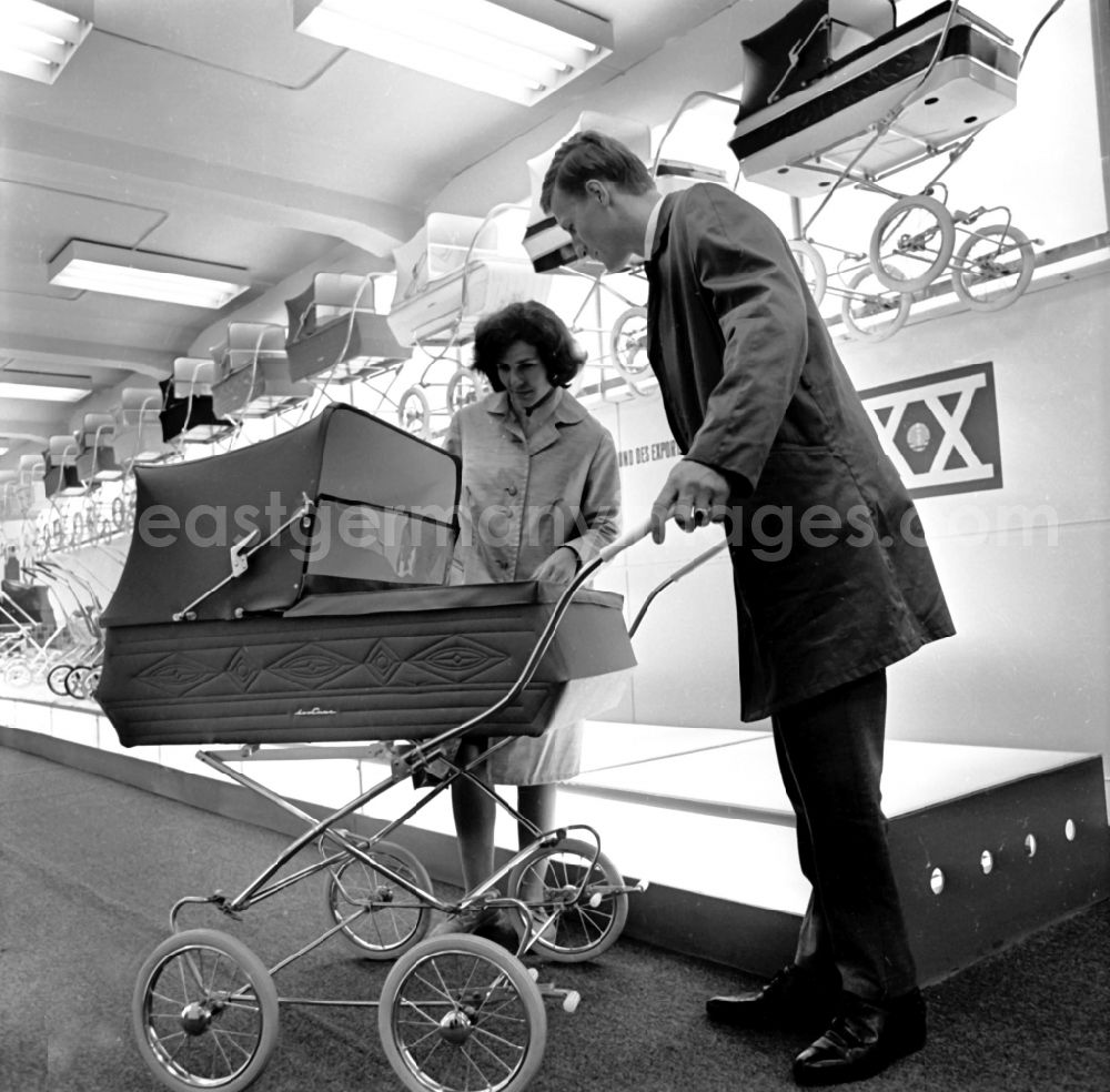 GDR picture archive: Leipzig - One parental couple checks a stroller at the Autumn Fair in Leipzig in Saxony