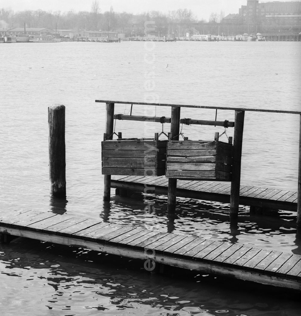 Berlin: Of chains hanging wooden boxes for fish on the quayside Rummelsburger lake in Berlin