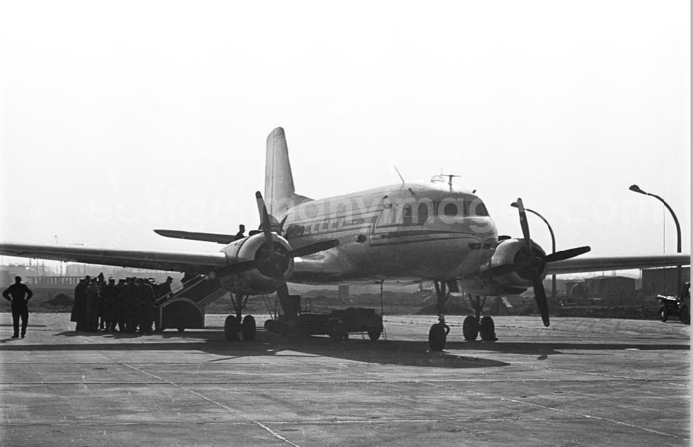 GDR picture archive: Leipzig - Passagiere besteigen ein Flugzeug vom Typ Iljuschin Il-14. Das Bild wurde auf dem Messeflughafen aufgenommen. Bestmögliche Qualität nach Vorlage!