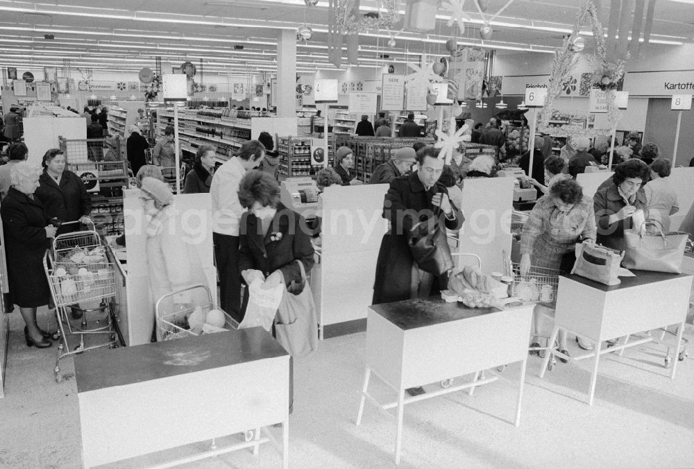 GDR image archive: Berlin - Customer at the pay at the cashier in a department store in Berlin, the former capital of the GDR, the German Democratic Republic