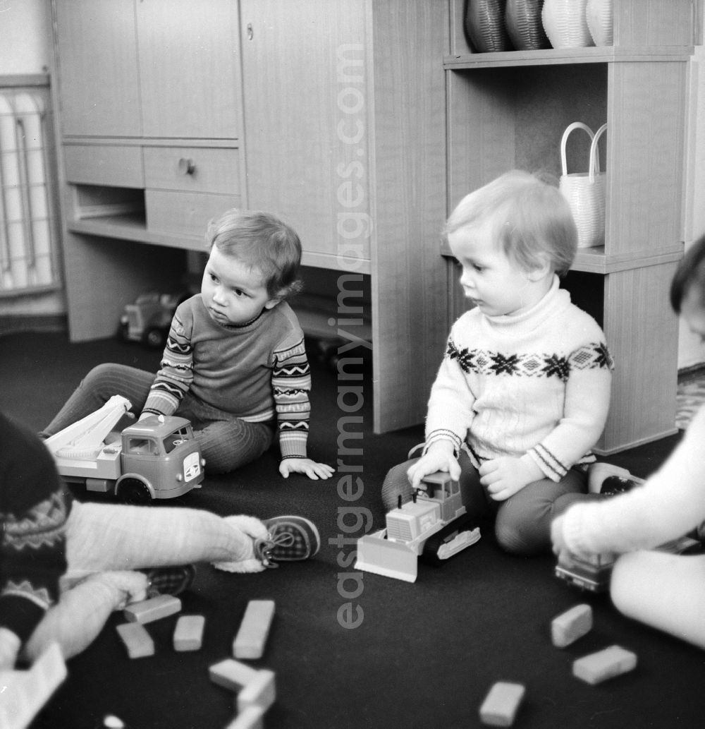 GDR picture archive: Berlin - Children at the daily employment in the playroom at the Children's Clinic in Klinikum Berlin-Buch in Berlin, the former capital of the GDR, the German Democratic Republic. A mother sitting with her baby sits treatment rooms