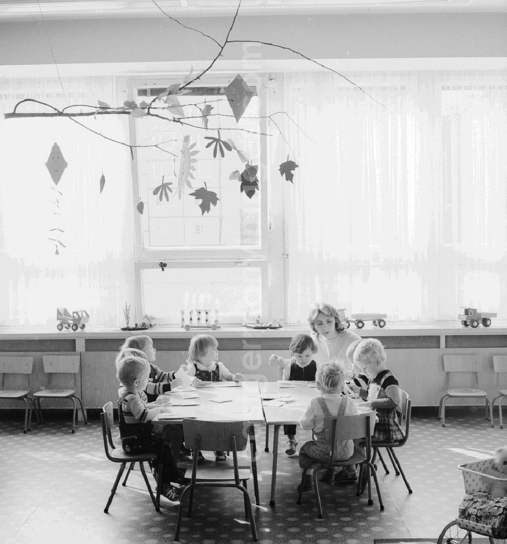 GDR picture archive: Berlin - In a crèche in Berlin, the former capital of the GDR, the German Democratic Republic. A teacher tinkering with the children