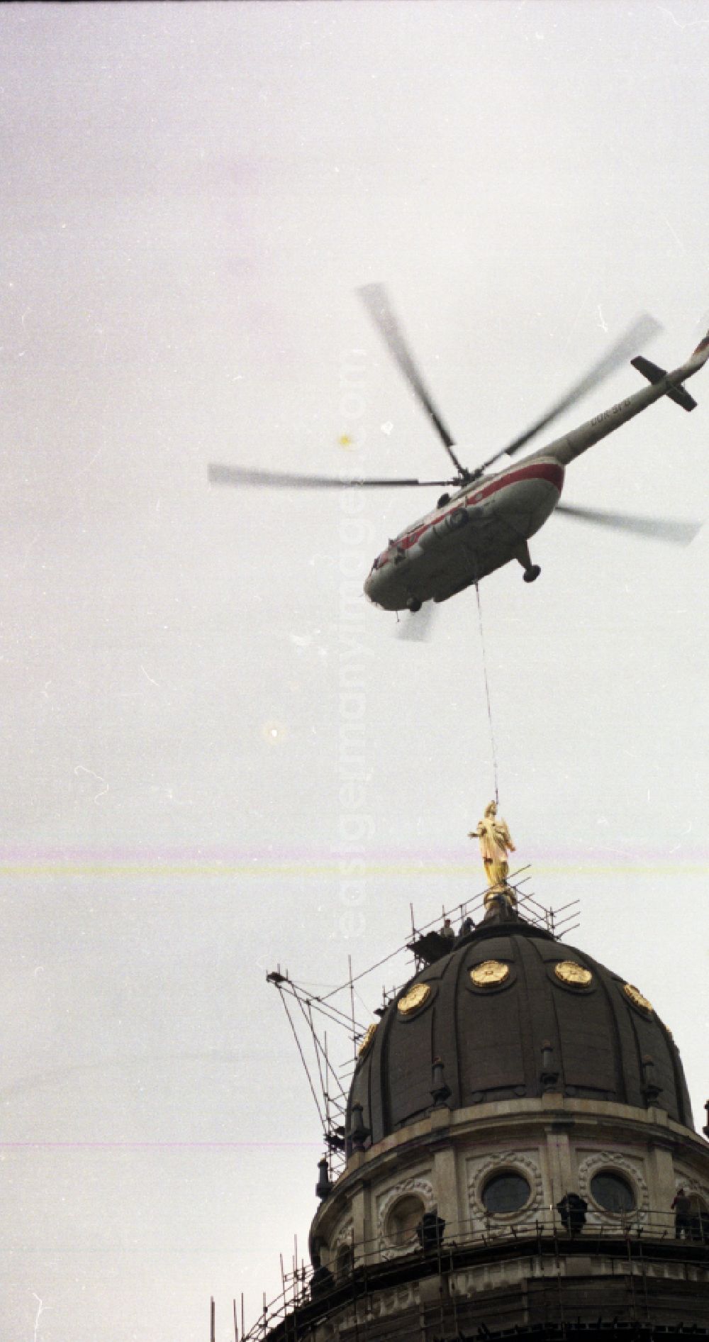 GDR image archive: Berlin - Special operation of an INTERFLUG - crane flight operation - Mi-8 helicopter to fly in the dome figure of the German Cathedral on Gendarmenmarkt in the district of Mitte in Berlin East Berlin on the territory of the former GDR, German Democratic Republic