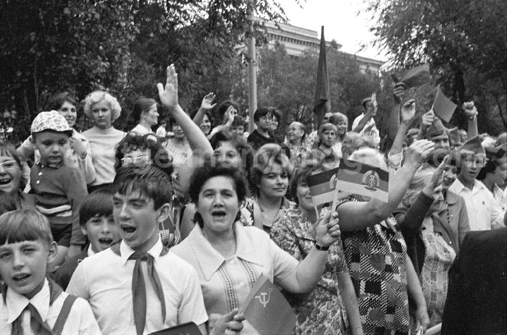 Wolgograd: Zuschauer stehen am Straßenrand und halten Winkelemente / Flaggen der DDR und Sowjetunion bei der Eröffnungsfeier des IV. Festival der Freundschaft in Wolgograd (auch Wolograd).