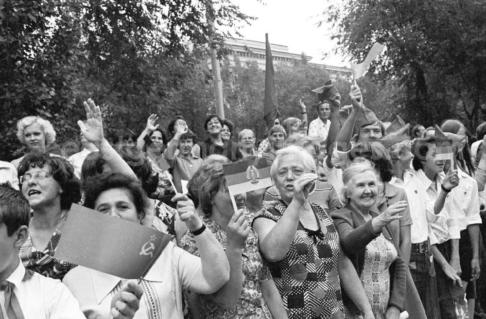 GDR image archive: Wolgograd - Zuschauer stehen am Straßenrand und halten Winkelemente / Flaggen der DDR und Sowjetunion bei der Eröffnungsfeier des IV. Festival der Freundschaft in Wolgograd (auch Wolograd).