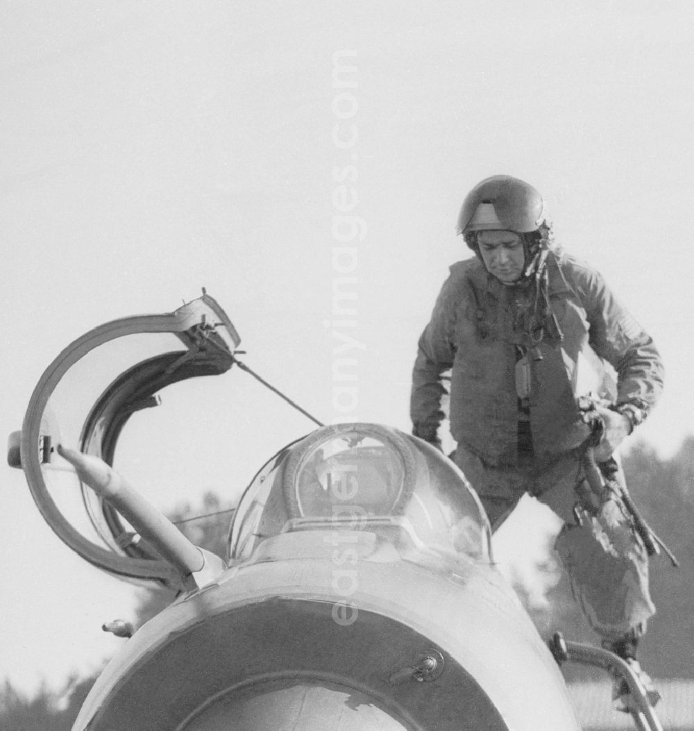 GDR picture archive: Peenemünde - Fighter pilot Major Heinz Kast when entering the cockpit of a MIG-21 fighter squadron of 9 in Peenemuende in Mecklenburg-Western Pomerania in the field of the former GDR, German Democratic Republic