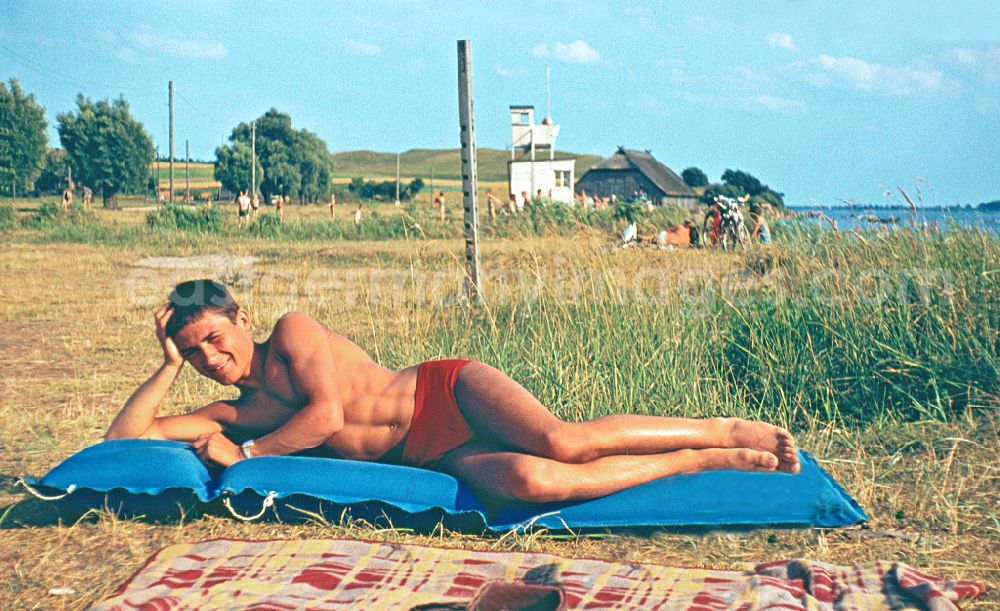 Sellin: Young people present current summer swimwear on an air mattress on the beach of the Greifswalder Bodden in Sellin, Mecklenburg-Western Pomerania in the area of ??the former GDR, German Democratic Republic