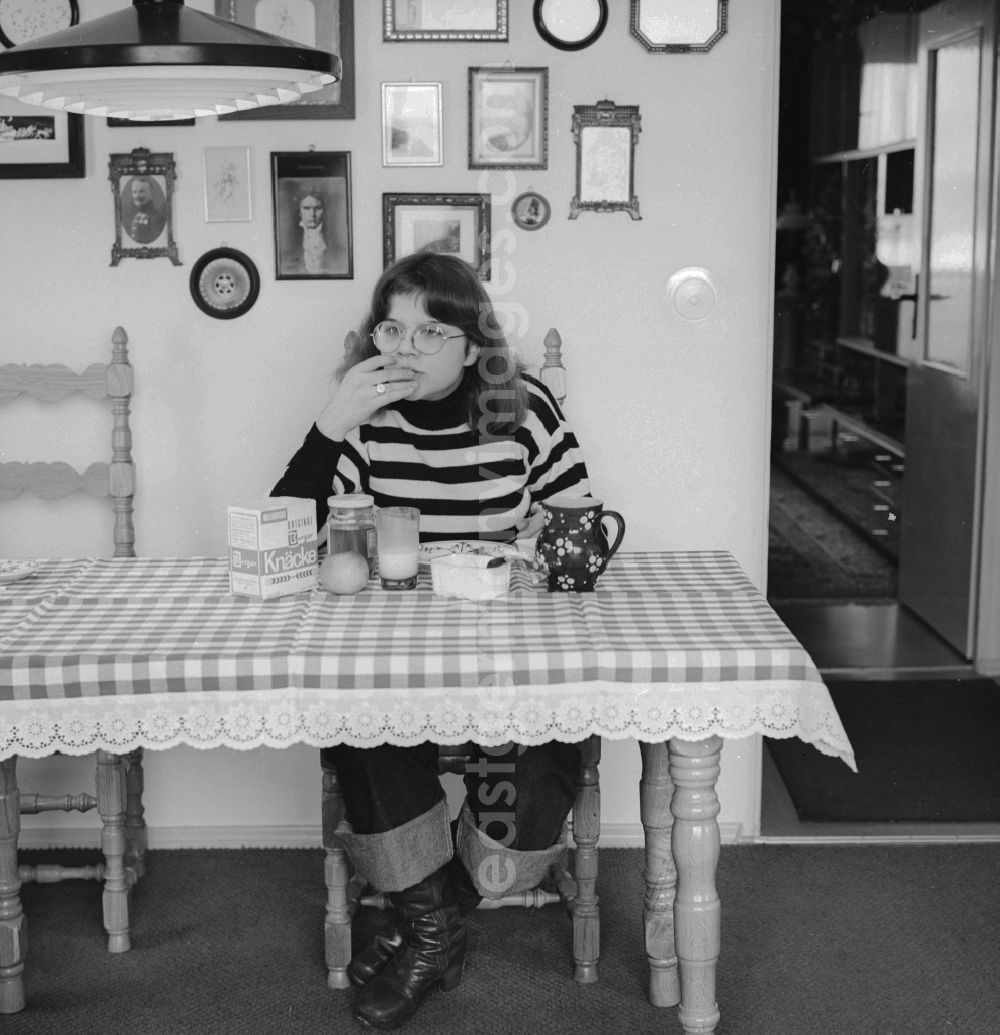 GDR picture archive: Berlin - Young woman having breakfast at the table in Berlin