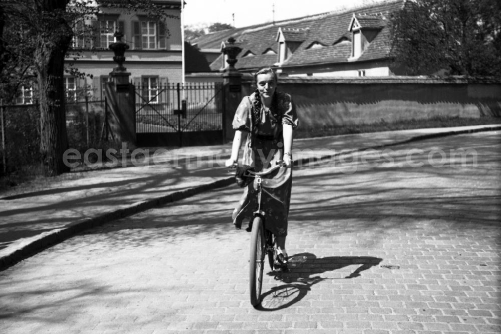 GDR picture archive: Merseburg - A young woman is on a bicycle on the way in Merseburg in the federal state Saxony-Anhalt in Germany