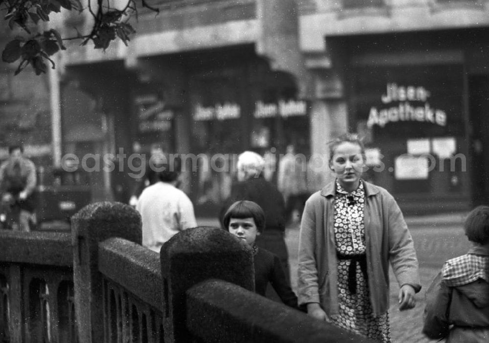 GDR image archive: Halle - Eine junge Frau mit Kind an der Hand vor einer Apotheke. Ebenfalls im Bild zu sehen sind weitere Passanten. Bestmögliche Qualität nach Vorlage!
