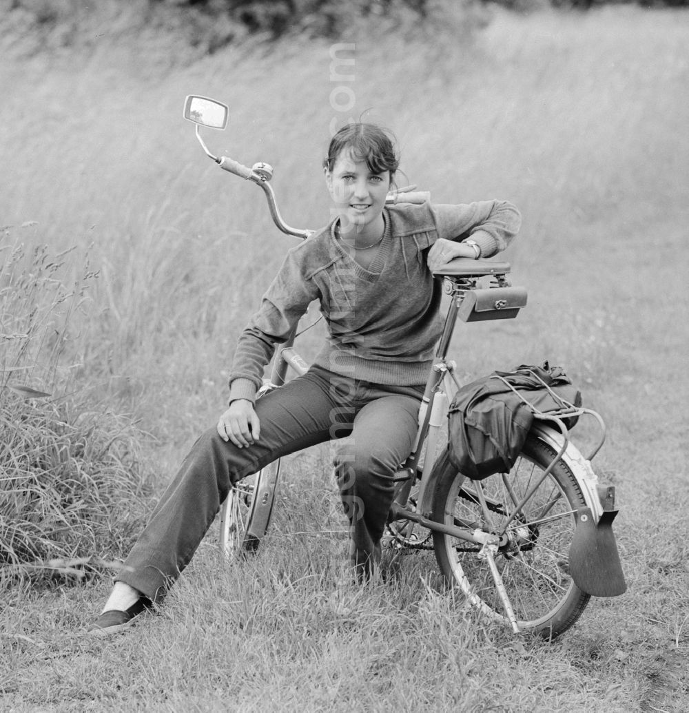 GDR photo archive: Hohen Neuendorf - Young woman sitting on a bicycle in Hohen Neuendorf in Brandenburg today