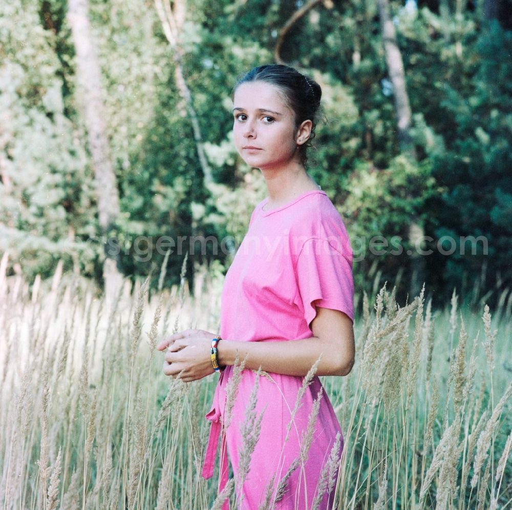 GDR picture archive: Grünheide (Mark) - Young Woman on a meadow in Gruenheide (Mark) in Brandenburg in the area of the former GDR, German Democratic Republic