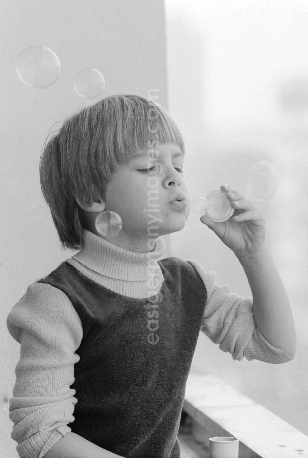 GDR picture archive: Berlin - Boy making soap bubbles on a balcony in Berlin, the former capital of the GDR, the German Democratic Republic