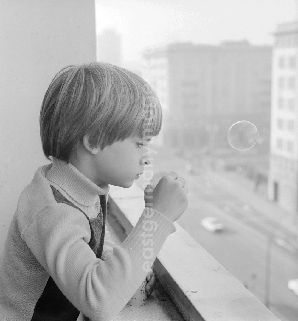 GDR photo archive: Berlin - Boy making soap bubbles on a balcony in Berlin, the former capital of the GDR, the German Democratic Republic
