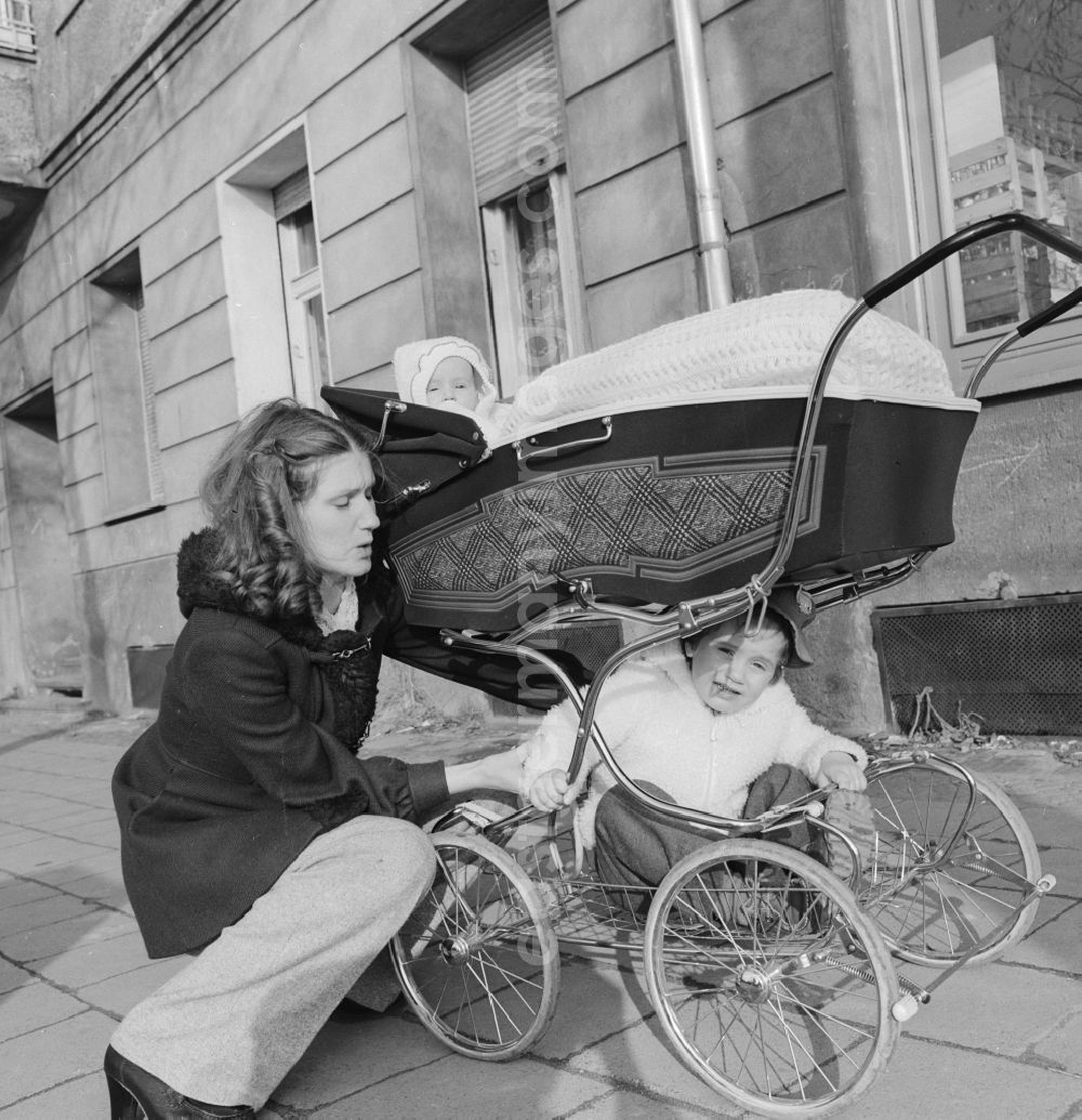 GDR picture archive: Berlin - Young mother with a pram on a walk in Berlin. Above is the baby in the basket and sits below the larger sibling