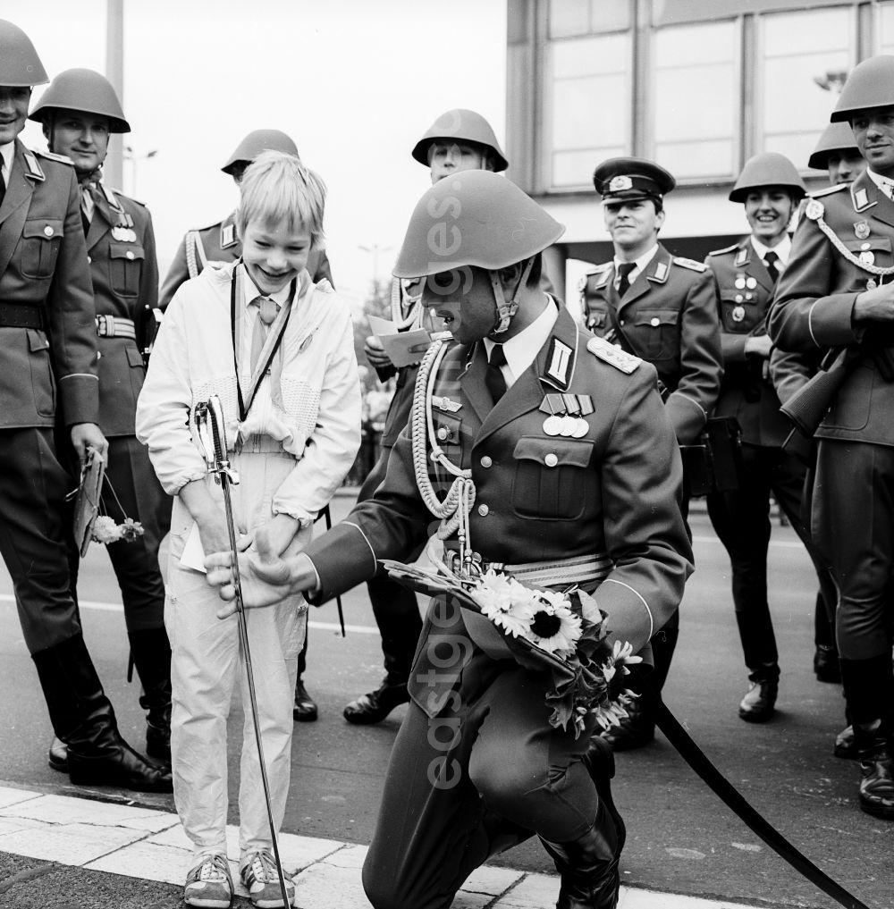 GDR photo archive: Berlin - Young pioneers present NVA soldiers with flowers and scarves in Berlin, the former capital of the GDR, German Democratic Republic