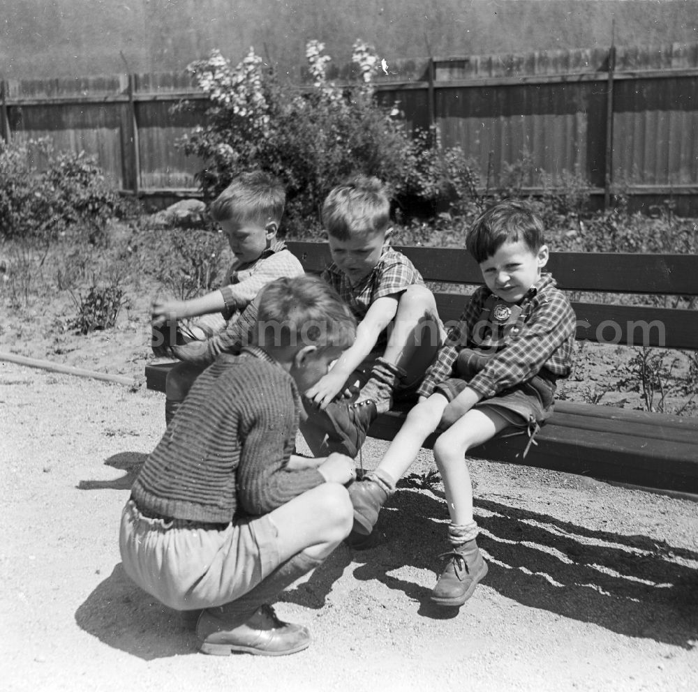 GDR photo archive: Arnstadt - Boys in short leather trousers sit on a garden bench in Arnstadt in the federal state Thuringia in the area of the former GDR, German democratic republic