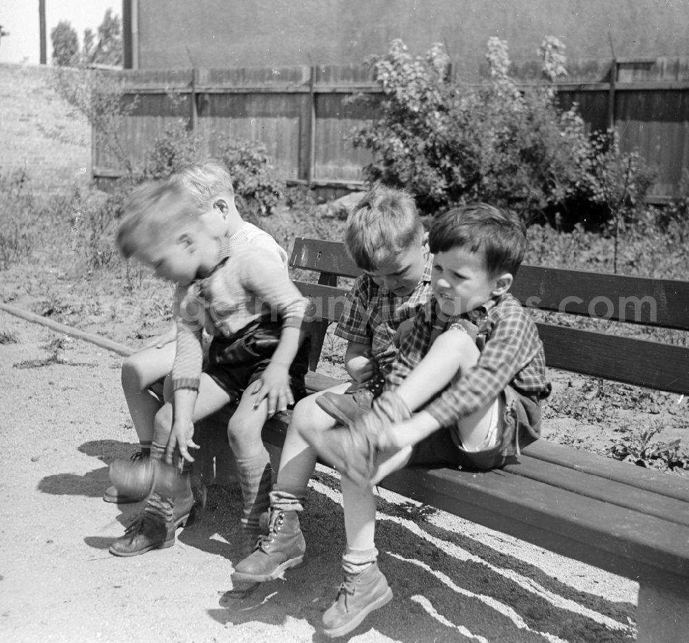 GDR picture archive: Arnstadt - Boys in short leather trousers sit on a garden bench in Arnstadt in the federal state Thuringia in the area of the former GDR, German democratic republic