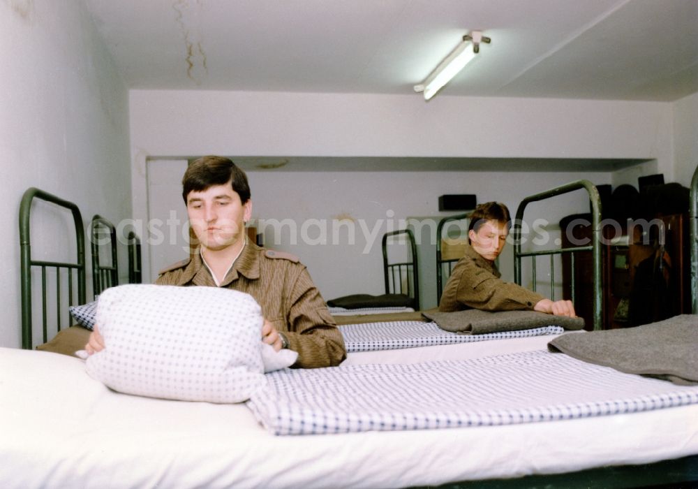 GDR photo archive: Beelitz - Young soldier when making the bed in an accommodation space of the NVA regiment, Friedrich Wolf in Beelitz in present-day state of Brandenburg