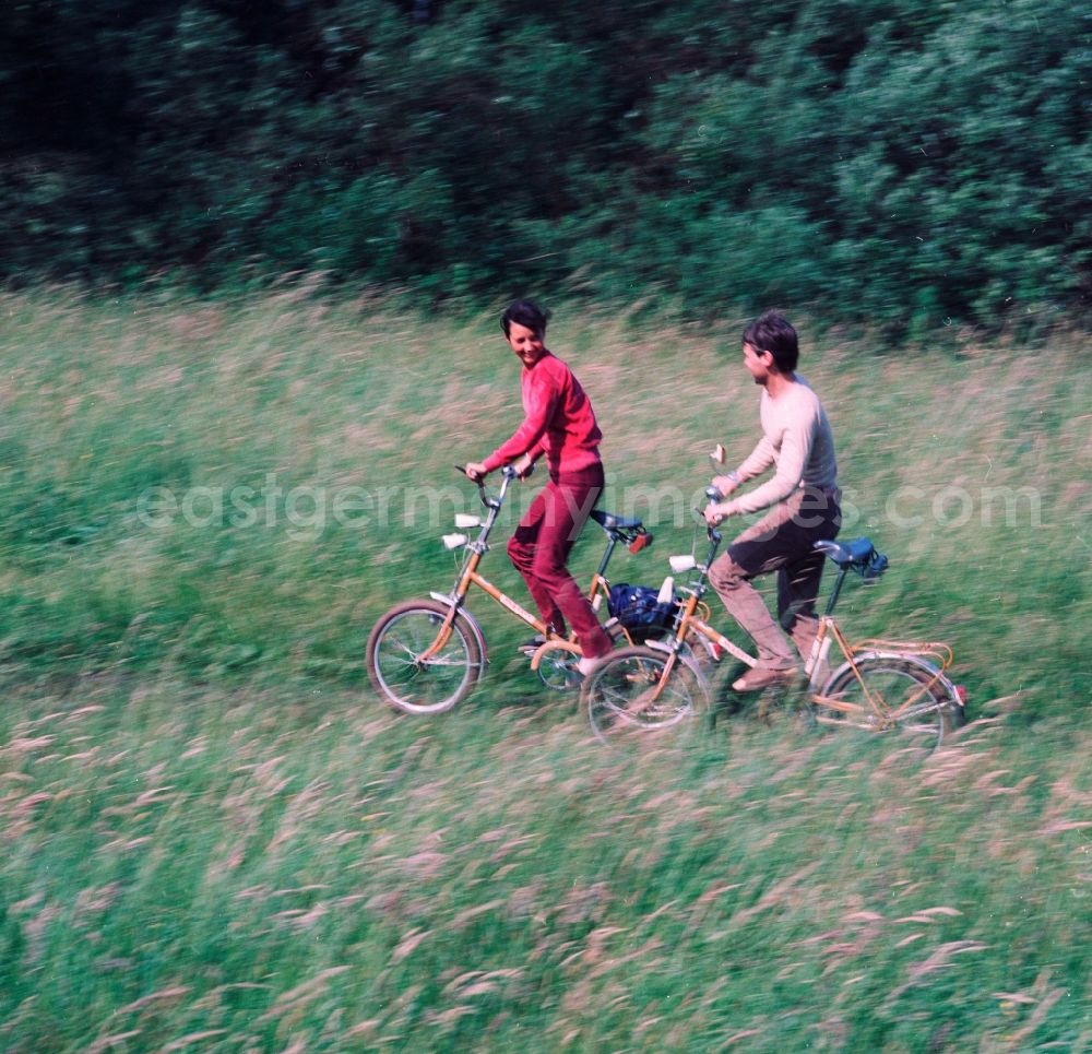 GDR photo archive: Hohen Neuendorf - Young couple on folding bikes on the road in the countryside in Hohen Neuendorf in Brandenburg today